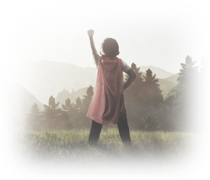 Child dressed as a superhero looking toward the horizon